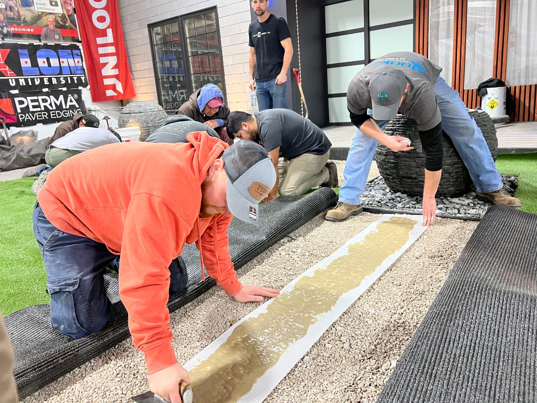 Professionals prepping an area for pavers.