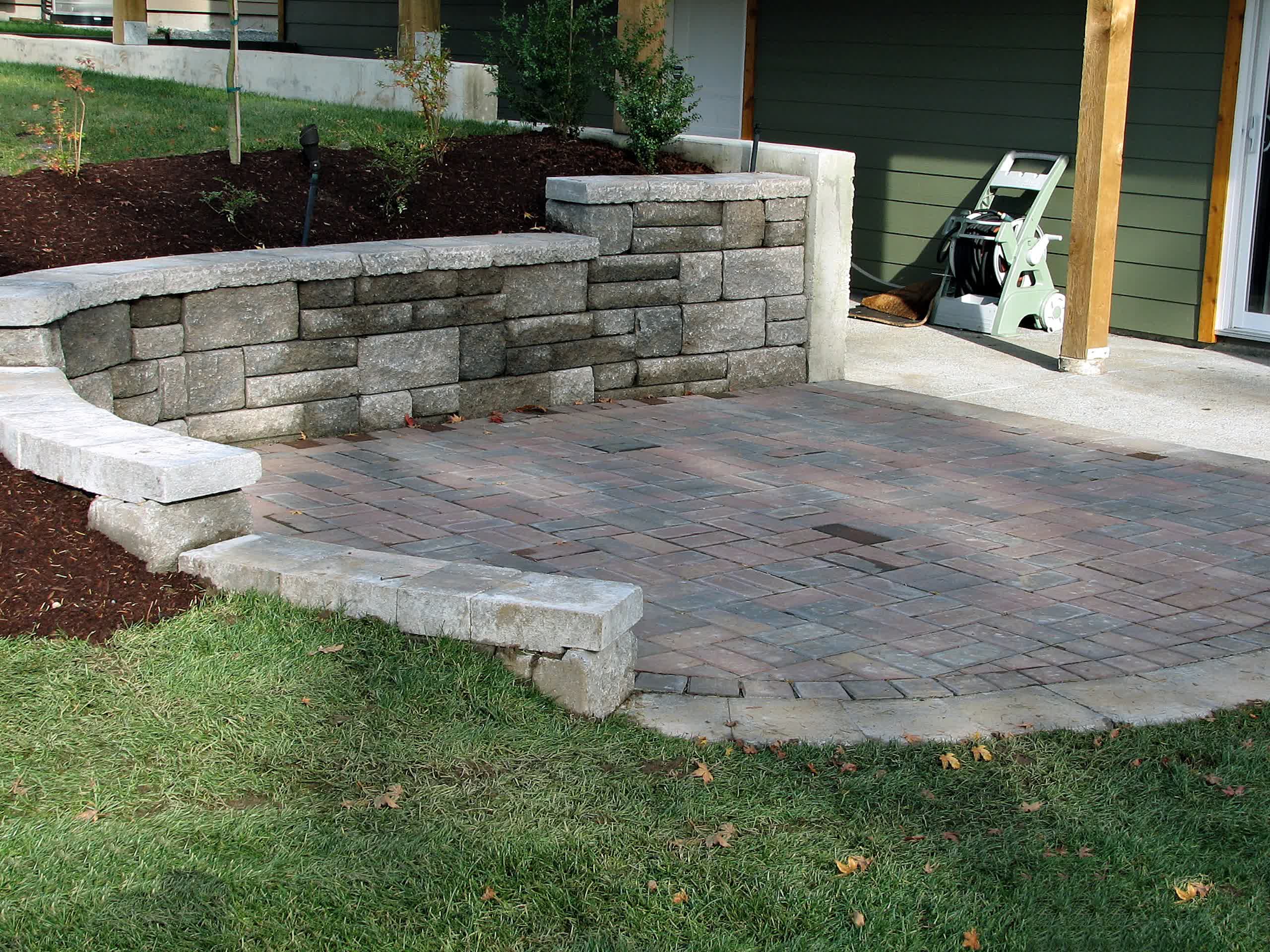 A professionally crafted retaining wall is attached to a matching patio.

