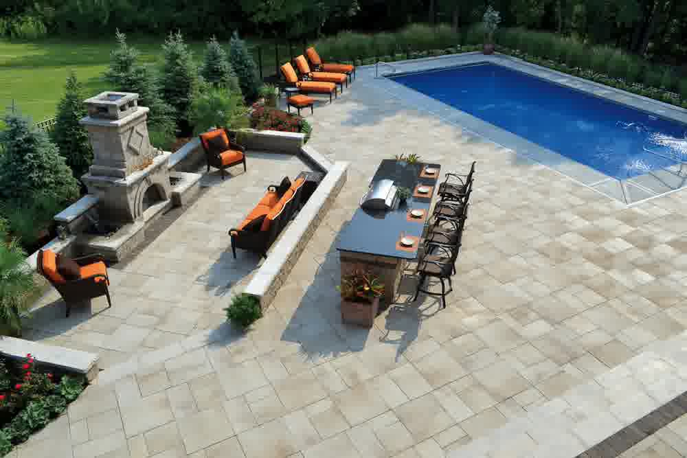 A beautiful patio with a furniture set next to a pool.